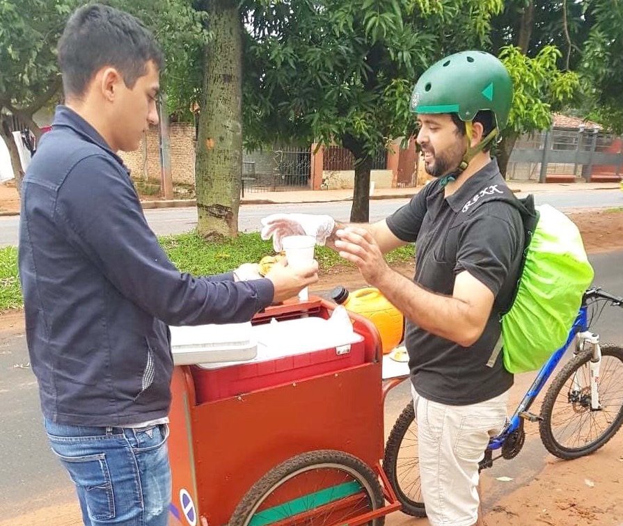 Joven ofrece café en granola recorriendo en bici por Asunción 
